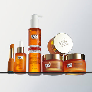 "Full RoC Multi Correxion Revive + Glow skincare range with Vitamin C, including eye balm, serum, cleanser, and moisturizers in orange and gold packaging displayed on a shelf.